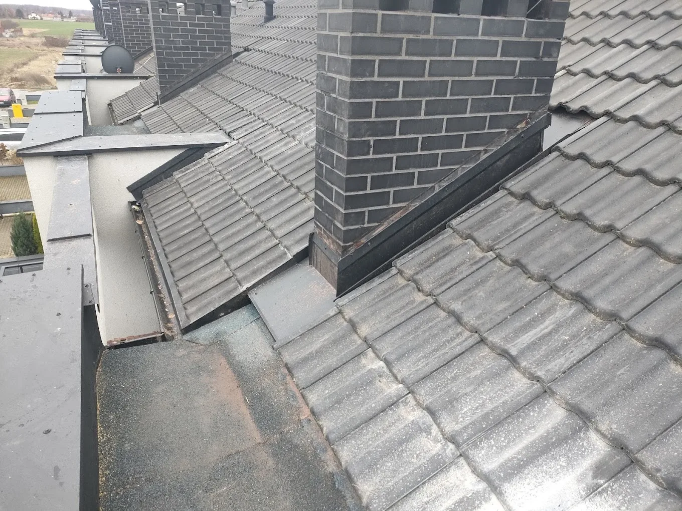 Złożona kalenica i obróbki kominów na dachu krytym dachówką ceramiczną